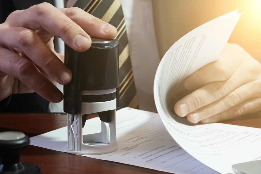 The businessman puts a stamp on the contract. Copy space.