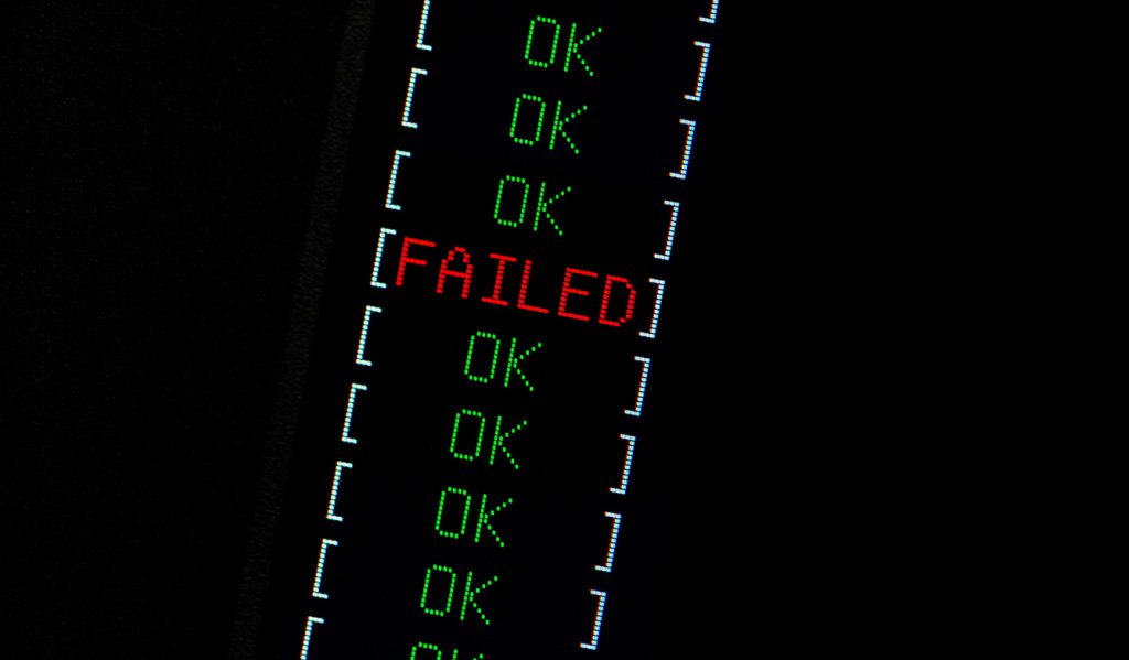 Computer failure simple abstract concept. One red FAIL indicator among many green OK passed checks. FAILED text on lcd display macro, closeup. Computation error, single chain link fails, emergency
