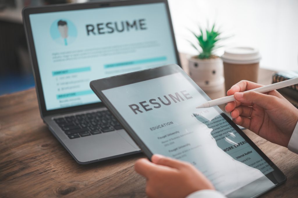 People are reviewing job applications before filling out their resume on the job application form in order to apply for a job at a company.