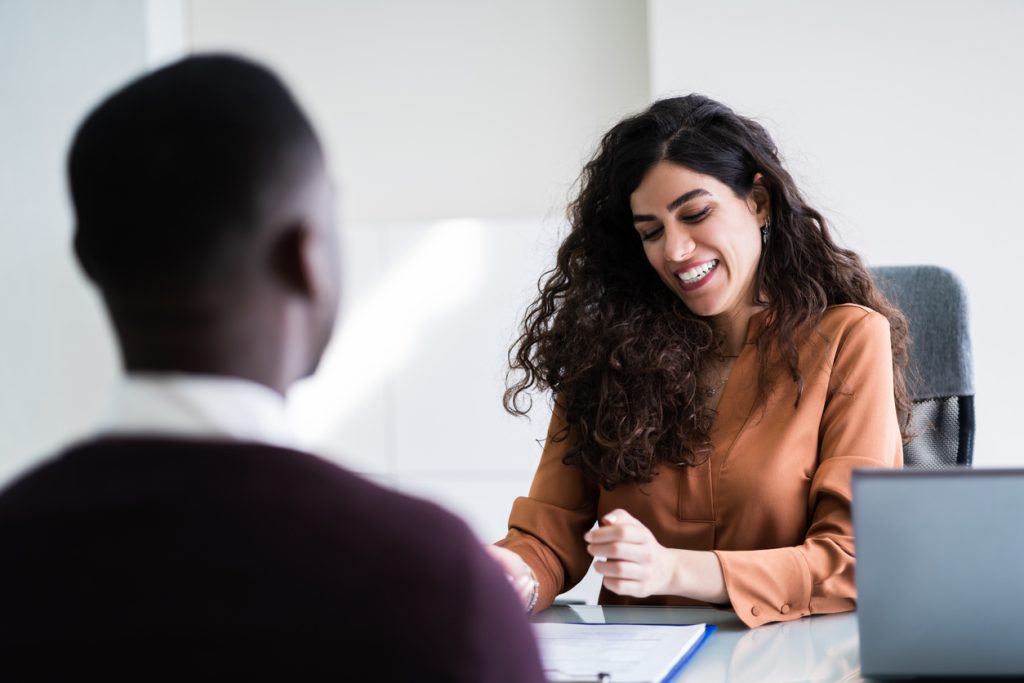 Female Manager Interviewing A Young Male Applicant In Office